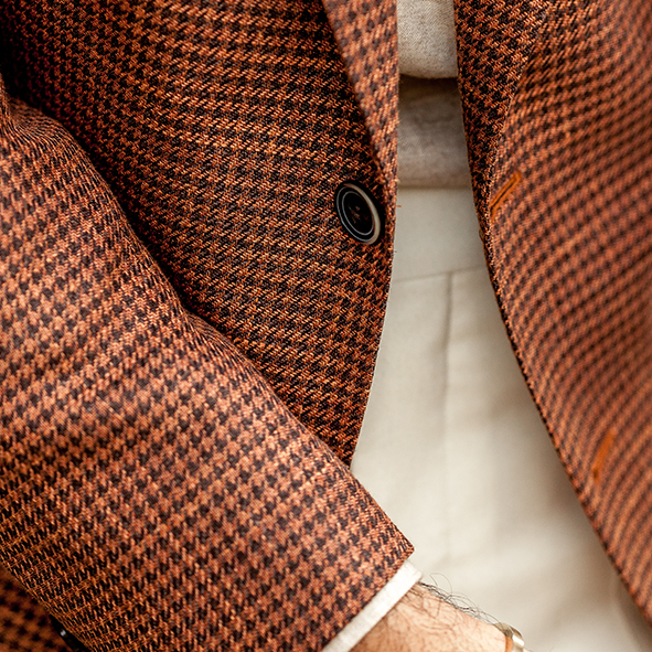 close up of person wearing a Luigi Bianci Mantova brown and red houndstooth wool silk and linen blazer